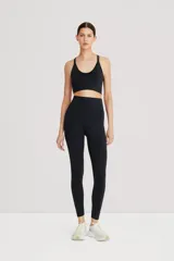 Calza larga negra de tiro alto, confeccionada en tejido suave y ligero de poliamida y elastano, con cintura doble para compresión media.