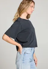 Remera corta negra de algodón con cuello redondo y mangas cortas.