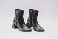 Botas de cuero negro con caña media, punta cuadrada y cierre lateral con cremallera.
