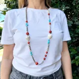 Collar largo con cadena plateada de eslabones y piedras de coral, turquesa y nácar. Incluye dijes en forma de corazón de nácar.