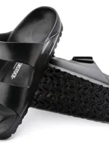 Sandalias Birkenstock Arizona, hechas de goma EVA color negro, con dos correas ajustables con hebilla.