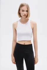 Top blanco sin mangas de poliéster, de punto canalé, al cuerpo y con cuello a la base.