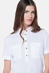 Camisa blanca de lino y algodón, con cuello clásico, mangas cortas y cierre frontal parcial con botones.