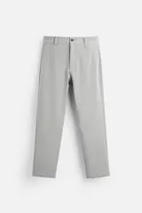 Pantalón de vestir gris claro, corte slim fit, confeccionado en tejido elástico. Cuenta con bolsillos frontales y traseros de vivo con botón. Cierre frontal con cremallera y botón.