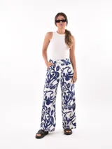 Pantalón palazzo con estampado de hojas y flores en tonos azul y blanco.