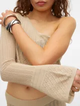 Top cropped color beige de tejido de punto calado, con un solo hombro y manga larga acampanada.