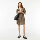 Vestido corto de punto crepé color beige con estampado animal print, escote en V y mangas cortas.