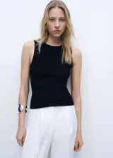 Top blanco de tejido de punto fino, sin mangas, cuello redondo y diseño entallado.