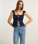 Pantalón mom jeans celeste con bordados de frutillas rojas.