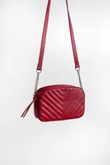 Cartera bandolera color rojo con diseño capitonado en forma de chevron. Tiene correa de cuero y cadena, cierre metálico y doble bolsillo interior.