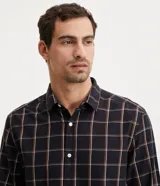 Camisa de franela a cuadros color negro, con botones blancos y corte clásico.