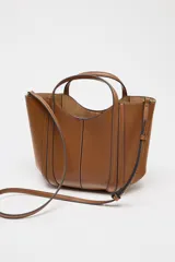 Bolso mini city color marrón con asa de mano y asa bandolera extraíble. Detalle de pespuntes en contraste y bolsa interior extraíble con cierre mediante cremallera.