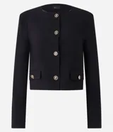 Saco negro de crepé con botones dorados diferenciados, mangas largas, cuello redondo y bolsillos con solapa.