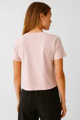 Remera de algodón color rosa pálido, de manga corta, corte ajustado y cuello en V.