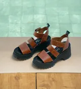 Sandalia de cuero vacuno, con suela de goma deportiva y tiras elásticas para mejor ajuste, diseñada para comodidad y estilo.