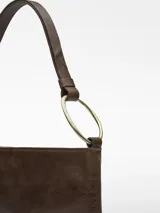 Bolso de hombro plano de cuero color marrón oscuro, con asa corta regulable con anilla metálica dorada. Tiene un compartimento con cierre de cremallera y bolsillo interior.