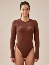 Body marrón de tejido acanalado, con cuello redondo y mangas largas.