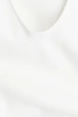 Vestido corto blanco de punto acanalado de algodón, de ajuste ceñido, con escote en U adelante y atrás, y breteles anchos con volado doble de tela.