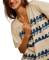 Remera color crema de manga corta holgada con estampado de olas azules.