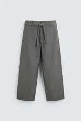Pantalón gris de corte recto con cinturón de la misma tela, bolsillos laterales y traseros.