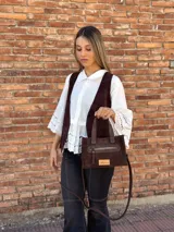 Cartera bandolera de cuero color marrón chocolate, con forro de tela y herrajes dorados. Tiene doble asa de mano y correa larga regulable y desmontable. Incluye bolsillo frontal con cierre y bolsillo interno.