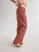 Pantalón de lino color ladrillo, de corte recto con cintura elastizada y tajos laterales en el ruedo.