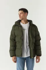 Campera puffer negra de nylon con cuello alto y capucha ajustable. Tiene bolsillos laterales y frontales con cierre.