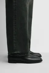 Mocasín de cuero negro con suela a tono y ligero tacón.