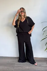Pantalón palazzo negro de lino, tiro alto con elástico en la cintura y pierna muy ancha y fluida.