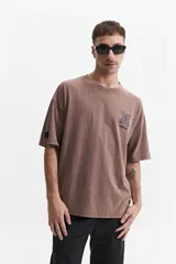 Remera gris oscuro con efecto gastado, corte boxy, manga corta y cuello redondo. Estampado en el frente con diseño abstracto y texto 'mistral'.