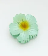 Pinza para el pelo en forma de flor de hibisco color verde agua con centro amarillo.