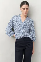 Camisa de manga larga estampada en azul y blanco, confeccionada en viscosa, con cuello mao con pequeño volado y mangas con leve volumen.