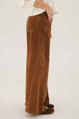 Pantalón de jean acampanado color caramelo con cintura alta y cinturón marrón con tachas.
