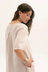 Vestido corto color arena, de lino, con escote en V y mangas cortas.