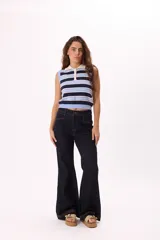 Pantalón jean de denim azul oscuro, corte wide leg, tiro medio y costuras a la vista en color ocre.