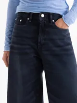 Jeans cropped de corte ancho y relajado, color índigo y negro, confeccionados en denim 100% algodón rígido.