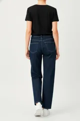 Pantalón de jean azul oscuro, de tiro alto y corte recto/holgado, con costura central marcada en el frente de ambas piernas.
