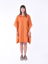 Vestido camisero naranja de corte holgado, con cuello clásico, abotonadura frontal y mangas cortas amplias.