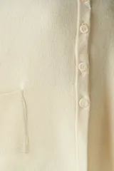 Capa marrón de tejido de punto 100% lana fina sin teñir, con botones y bolsillos en la delantera. Diseño exclusivo de Don Baez, hecha en Uruguay.