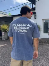 Remera celeste con acid wash y estampa en la espalda con la frase "We could all be better humans. Prioritize yourself".