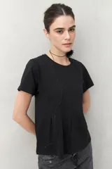 Remera blanca de manga corta con cuello redondo y costuras verticales en el frente.