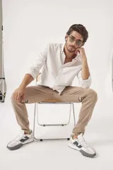 Camisa de lino color blanco, de corte regular, con cuello clásico y mangas largas.