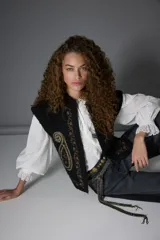 Camisa blanca de manga larga con volados en el cuello y puños de encaje.