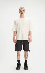 Remerón color beige de corte crop y calce oversize, con hombros caídos y cuello redondo.