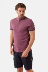 Remera de manga corta color vino tinto jaspeado con cuello mao y tapeta de botones. Los bordes de las mangas tienen un ribete en color azul marino.