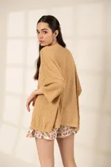 Remerón tejido color ocre, de corte oversize, con mangas 3/4 y cuello redondo.