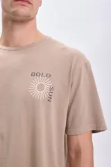 Remera manga corta oversize color taupe con estampa frontal de un sol y la frase 'Bold Sun'.