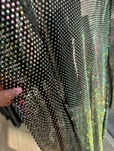 Minivestido negro con strass tornasolado, mangas largas de red y corte ajustado.