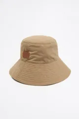Gorro tipo bucket color marrón de gabardina con etiqueta de cuero con logo de la marca.