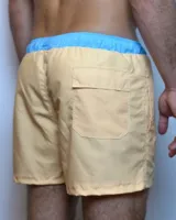 Short de baño color salmón con cintura elástica celeste y cordón ajustable blanco.